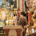 Zdjęcie przedstawia Wójta Gminy Przemęt przemawiającego podczas uroczystości w kościele.