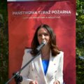 Na zdjęciu Pani Patrycja Pabich podczas swojego przemówienia. W tle roll up "Państwowa Straż Pożarna Komenda Powiatowa w Wolsztynie".