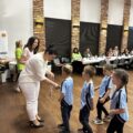 Na zdjęciu Pani Monika Maćkowiak wręcza dzieciakom z przedszkola w Buczu medale. W tle dyrektorzy szkół i przedszkoli.