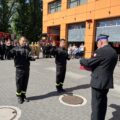 Na zdjęciu dwóch nowych strażaków składa ślubowanie. W tle reszta strażaków.