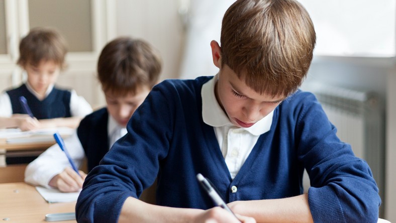 Na zdjęciu dzieci piszące egzamin