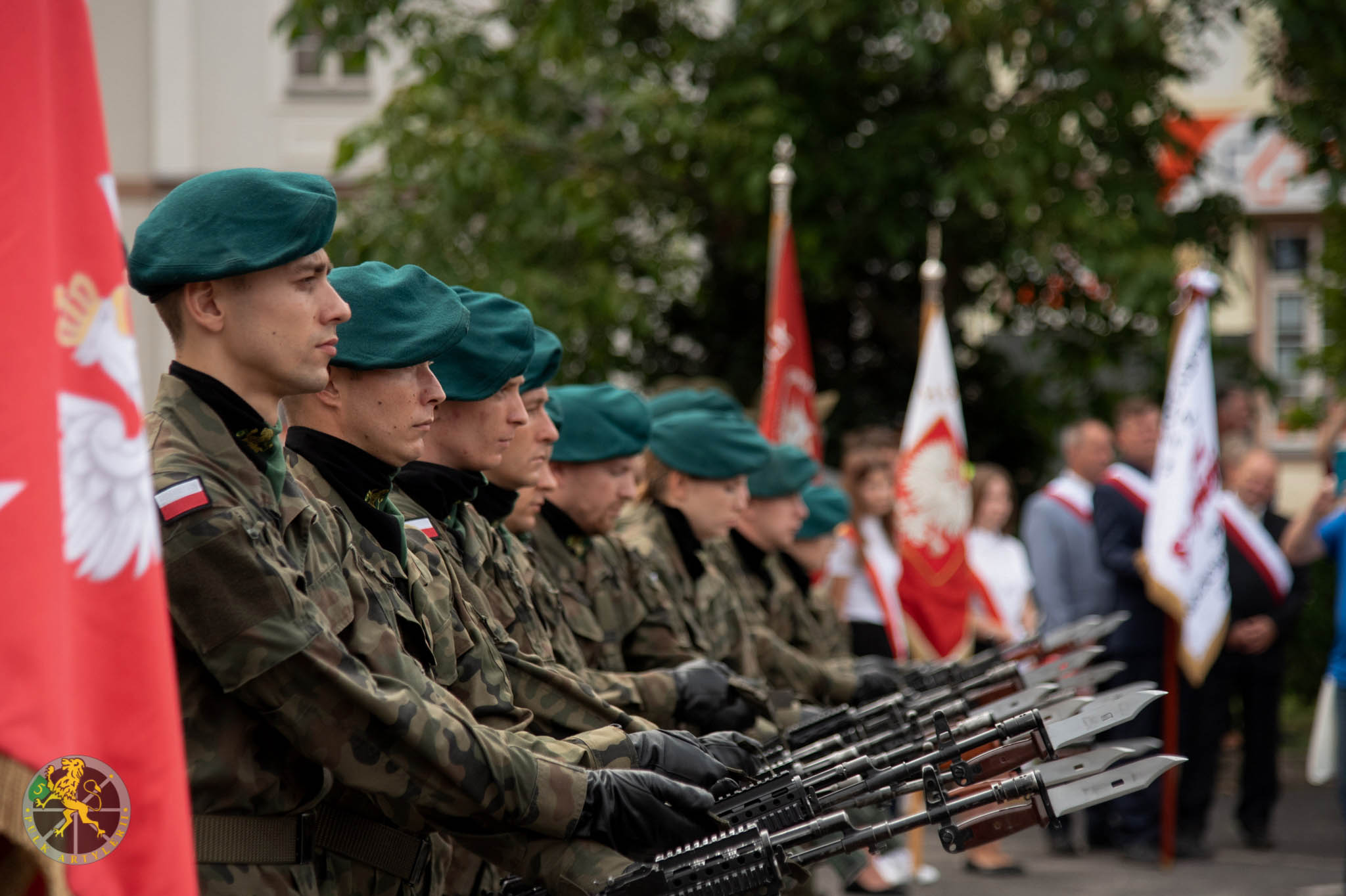 Na zdjęciu żołnierze z bronią, ustawieni w jednym rzędzie.