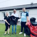 Na fotografii wójt gminy, radna oraz prezes klubu. Wyżej wymienieni wspólnie trzymają czarną koszulkę, na której widnieje logo klubu sportowego oraz napis: "Twardym trzeba być nie miętkim!". Na zdjęciu także widoczny nowy traktor.