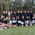 Grupowe zdjęcie drużyn z Barchlina. Na zdjęciu trzy osoby pozują z pucharami, dyplomami i czekami.