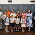 Grupowe zdjęcie nagrodzonych uczniów wraz z rodzicami, wójtem, przewodniczącą rady i wicedyrektorem szkoły z Kaszczoru.