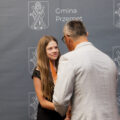 Na fotografii wójt wręcza nagrodę uczennicy. W tle ścianka gminy.