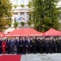Na zdjęciu uczestnicy uroczystości – strażacy, zaproszeni goście oraz przedstawiciele władz samorządowych – pozują do wspólnej fotografii na tle czerwonych namiotów Państwowej Straży Pożarnej.