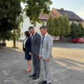 Zdjęcie przedstawia wójta, zastępcę wójta i skarbnik, którzy wykonują ukłon w stronę pomnika. Zdjęcie ukazuje moment po złożeniu wiązanki i zniczy.