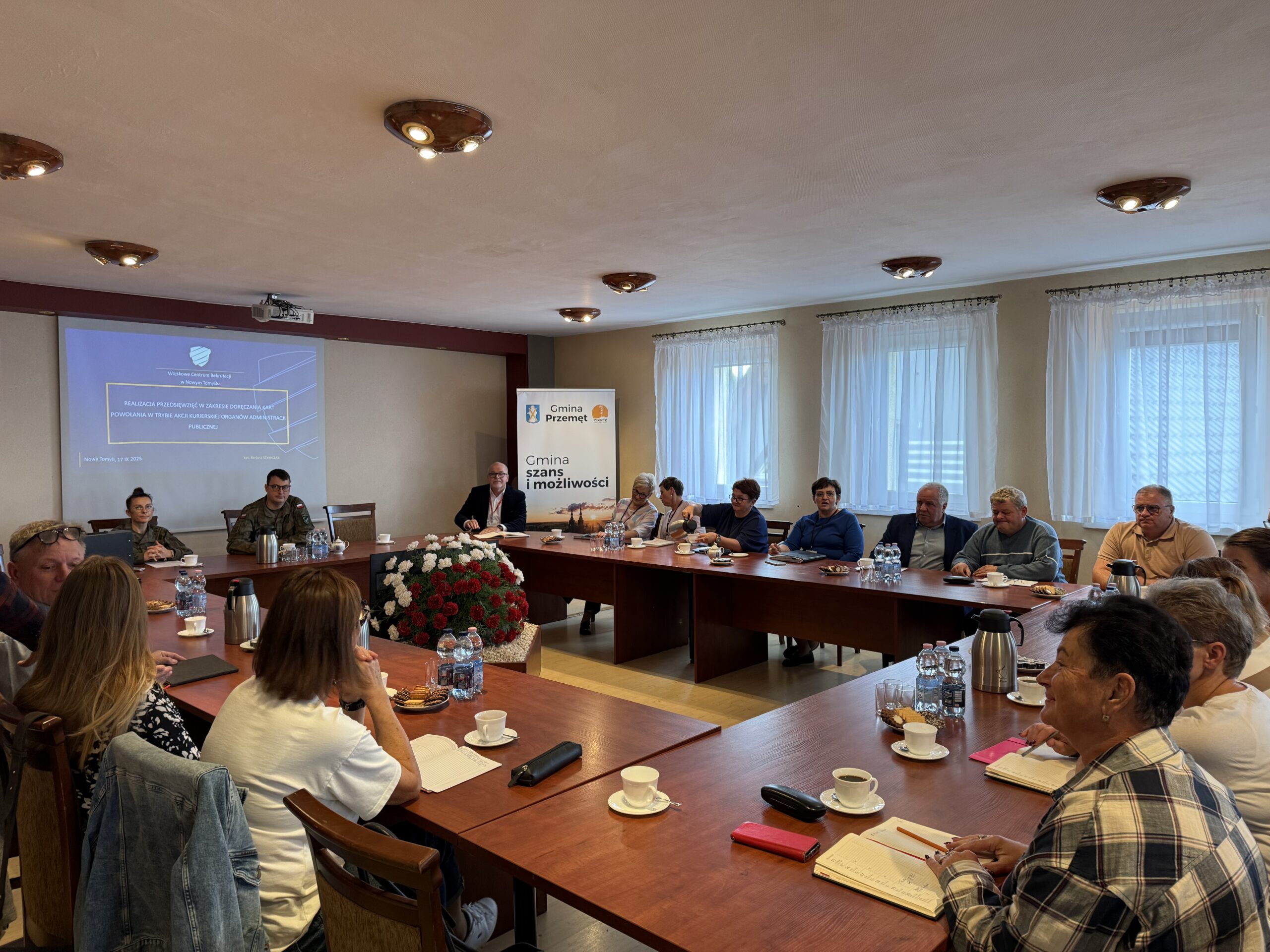 Na fotografii uczestnicy szkolenia oraz prowadzący. Wszyscy siedzą w sali sesyjnej.