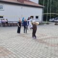 Na fotografii uczniowie skaczą przez dużą skakankę.