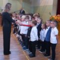 Na fotografii dyrektor szkoły pasuje pierwszoklasistów na uczniów.