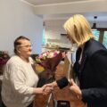 Na zdjęciu zastępca kierownika USC wręcza jubilatce bukiet kwiatów.