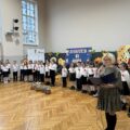Na fotografii pierwszoklasiści podczas występu. Na zdjęciu także widoczna wychowawczyni jednej z klas.