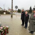Na fotografii widoczna jest delegacja oddająca hołd powstańcom przy pomniku w Mochach.