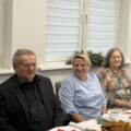 Na zdjęciu widoczna trójka seniorów, którzy siedzą przy wigilijnym stole.