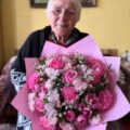 Na fotografii jubilatka z bukietem kwiatów.